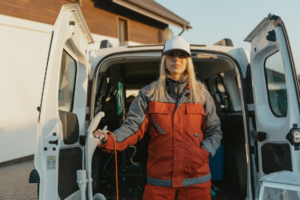 An image of a woman in orange clothes standing near a van