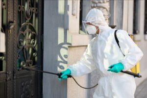 a healthcare worker disinfecting a door