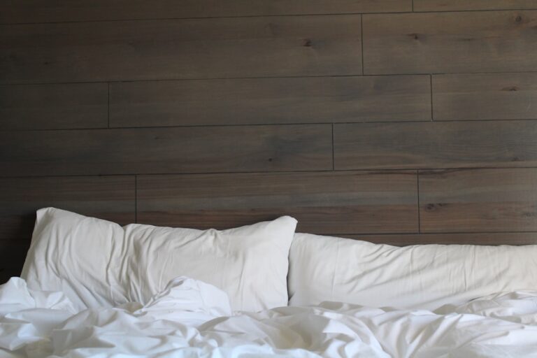 An image of a bed with white pillows and covers