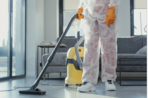 A professional exterminator using a vacuum cleaner after a pest control treatment
