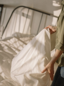 Person inspecting bed for signs of bed bugs