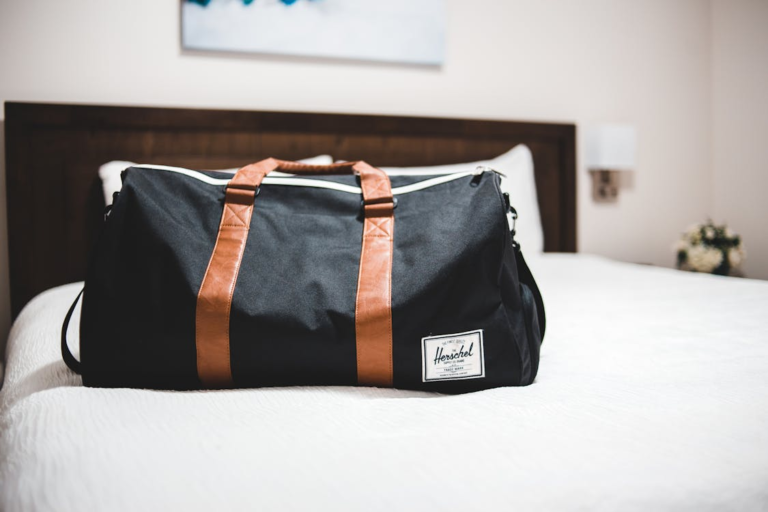 A bright vacation rental bedroom near Lake Michigan Beach showing luggage placed on a bed, highlighting travel-related bed bug risk