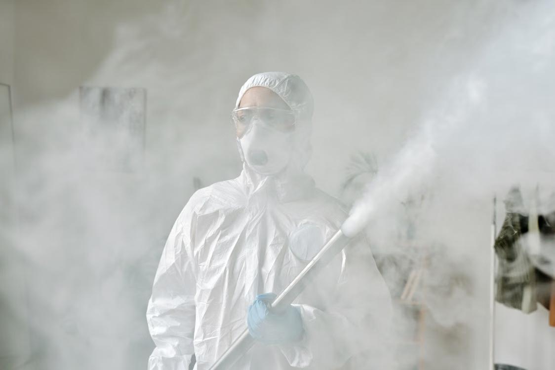 a person spraying a room with pesticide